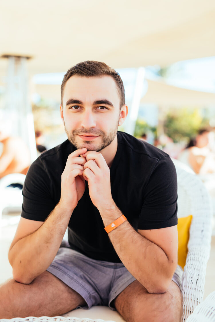Young man relax at outdoor cafe. Man on luxury hotel terrace with sea view at resort restaurant.